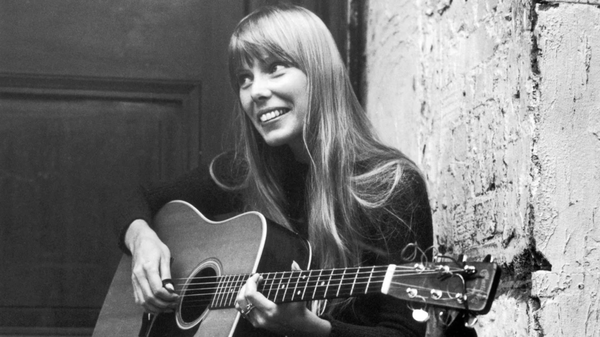 Canadian singer and songwriter Joni Mitchell strums her guitar outside The Revolution club in London in 1968. 